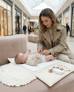 Майка сменя пелена на бебе върху преносим повивалник AuraBaby